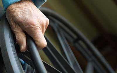 Senior hand on wheelchair